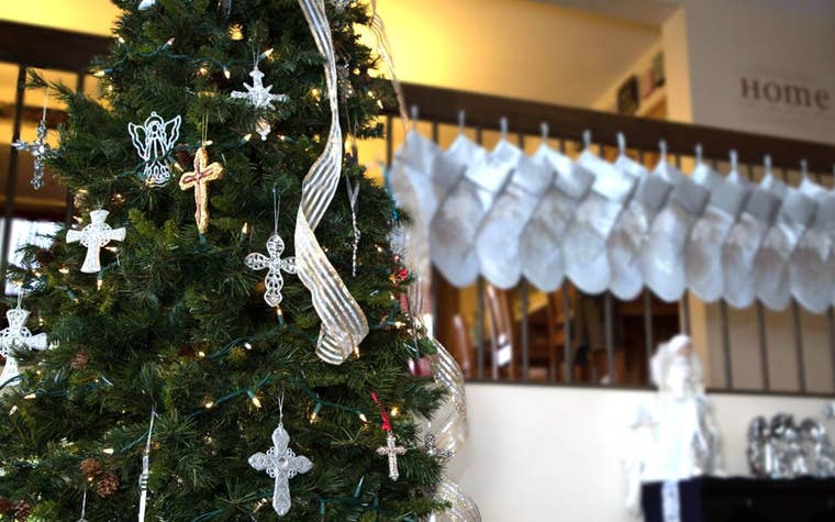 stockings hang on a banister next to a christmas tree. 