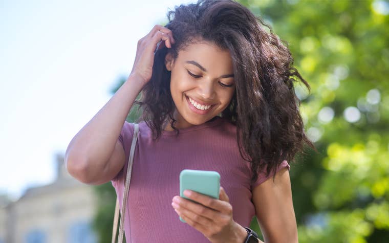 African American Teen Girl Smiling Looking at Her Phone