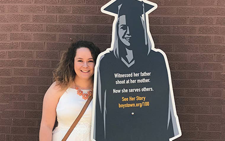 Boys Town student next to her cardboard cutout of 100 years