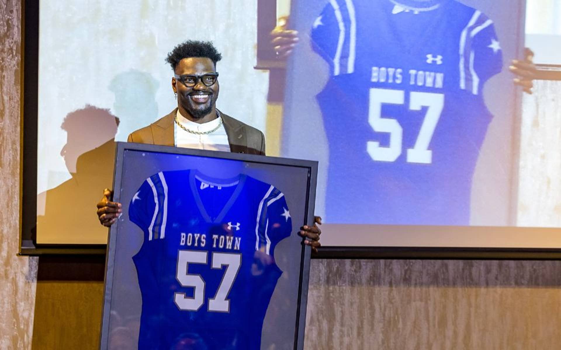 Shaquil Barrett holding a his blue, number 57 jersey.